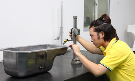 Chinese technician operating horizontal deep drawing press at Hengya factory